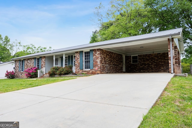 ranch-style house featuring brick siding, driveway, a front yard, and an attached carport