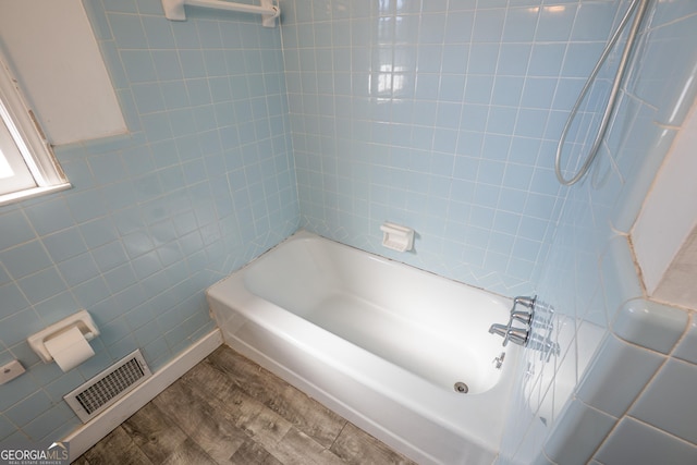 full bathroom with wood finished floors, visible vents, and tile walls
