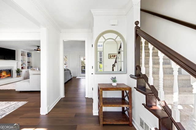 corridor with built in shelves, visible vents, crown molding, and wood finished floors