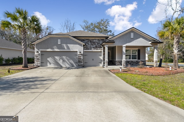 craftsman-style home featuring a porch, a garage, stone siding, driveway, and a front lawn