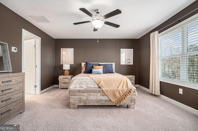 bedroom with baseboards, visible vents, a ceiling fan, and light colored carpet