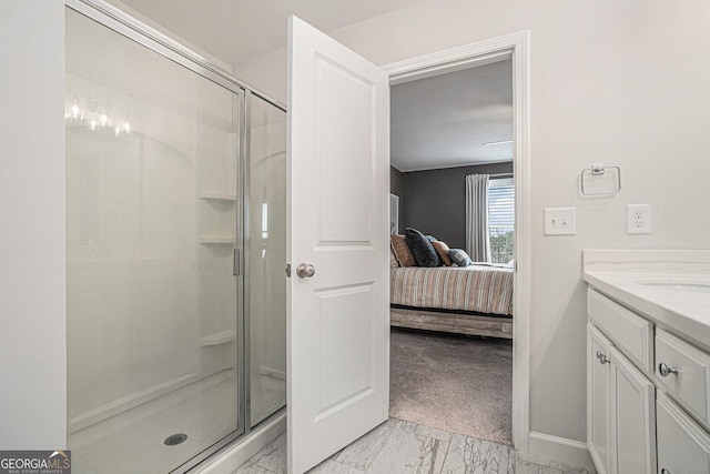 ensuite bathroom featuring a stall shower, baseboards, ensuite bathroom, marble finish floor, and vanity