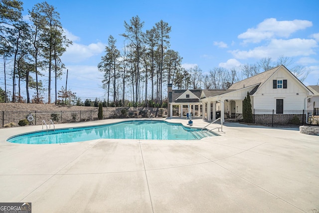 pool featuring fence and a patio