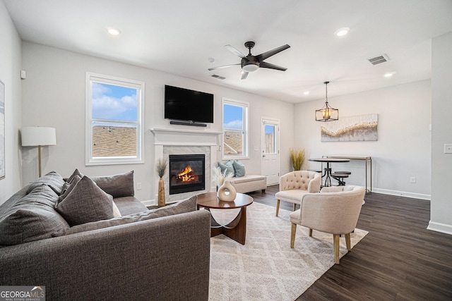 living room featuring visible vents, plenty of natural light, baseboards, and wood finished floors