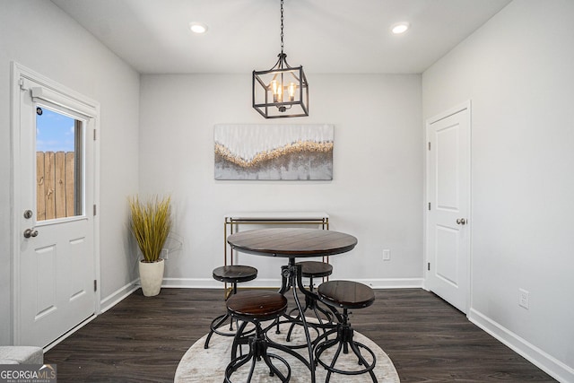 dining space featuring recessed lighting, a notable chandelier, baseboards, and wood finished floors