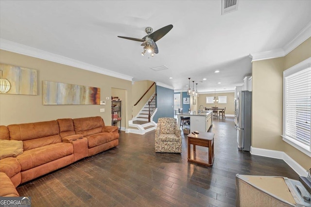 living area featuring dark wood-style flooring, visible vents, stairway, ornamental molding, and baseboards