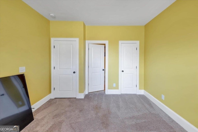 unfurnished bedroom featuring carpet floors and baseboards