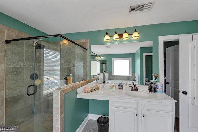 full bathroom featuring vanity, a shower stall, and visible vents