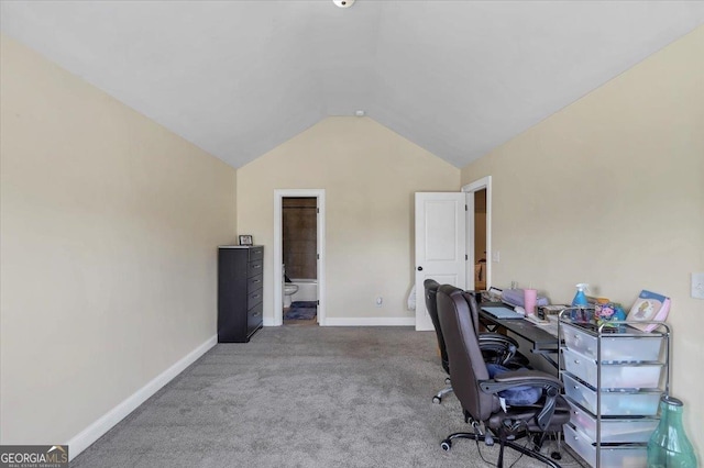 carpeted home office featuring baseboards and vaulted ceiling