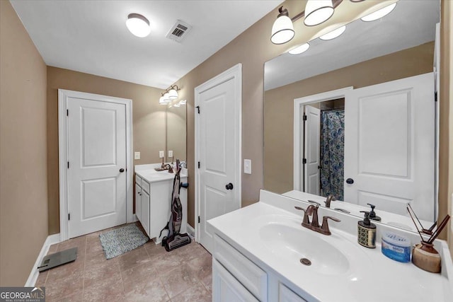 bathroom with visible vents, vanity, and baseboards