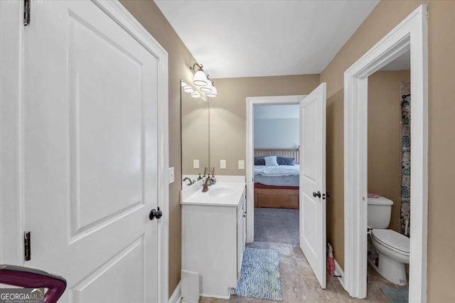 bathroom featuring toilet, vanity, and ensuite bathroom