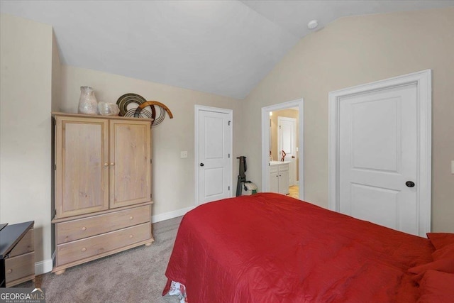 bedroom with ensuite bathroom, baseboards, vaulted ceiling, and light colored carpet