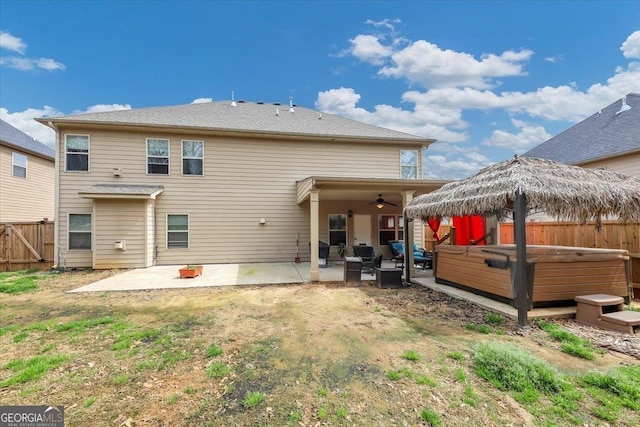 rear view of house featuring a hot tub, a patio, ceiling fan, fence, and a gazebo