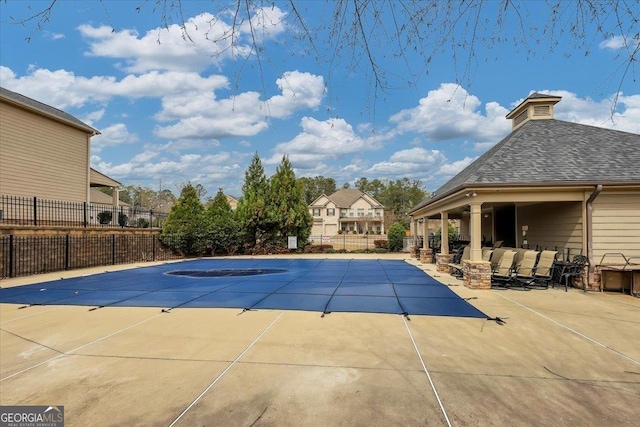 community pool featuring a patio and fence