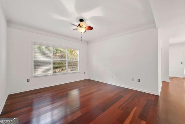 empty room featuring crown molding, baseboards, and wood finished floors