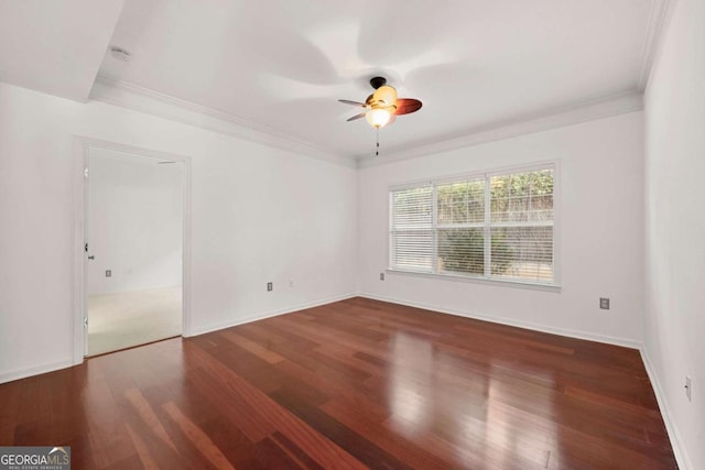 empty room with ornamental molding, a ceiling fan, baseboards, and wood finished floors