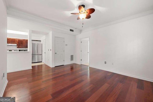 interior space featuring ornamental molding, visible vents, dark wood finished floors, and freestanding refrigerator