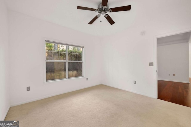 carpeted spare room featuring a ceiling fan