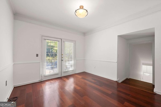 empty room featuring baseboards, ornamental molding, wood finished floors, and french doors