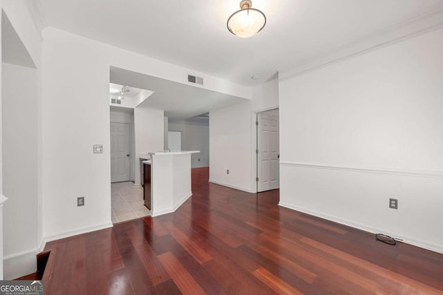 unfurnished living room featuring wood finished floors, visible vents, and baseboards