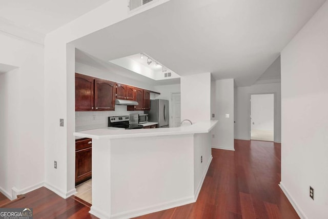 kitchen featuring under cabinet range hood, tasteful backsplash, stainless steel appliances, and light countertops