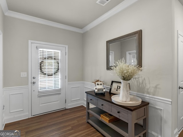 doorway featuring ornamental molding, wainscoting, dark wood finished floors, and visible vents