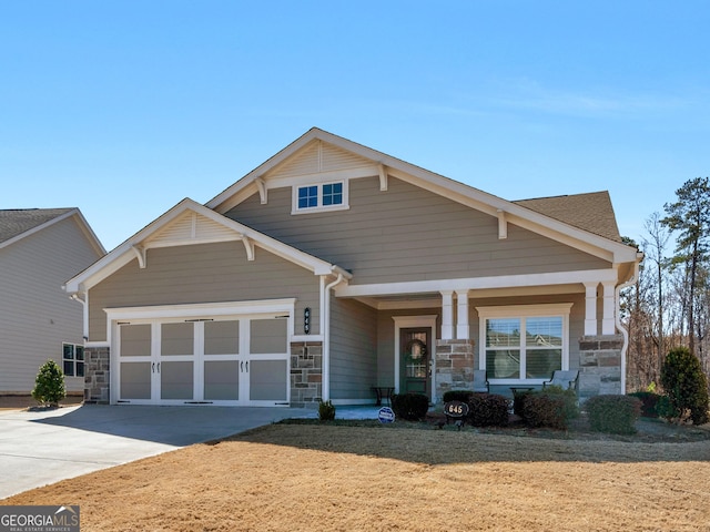 craftsman inspired home featuring stone siding, driveway, and an attached garage