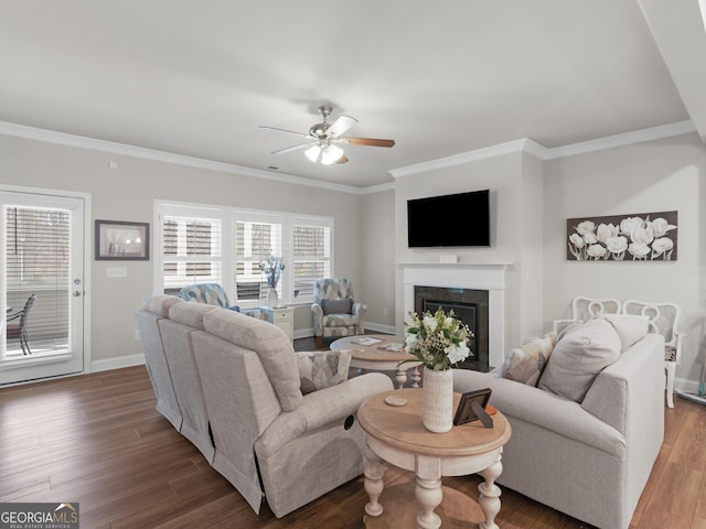 living area with ornamental molding, wood finished floors, a high end fireplace, and baseboards