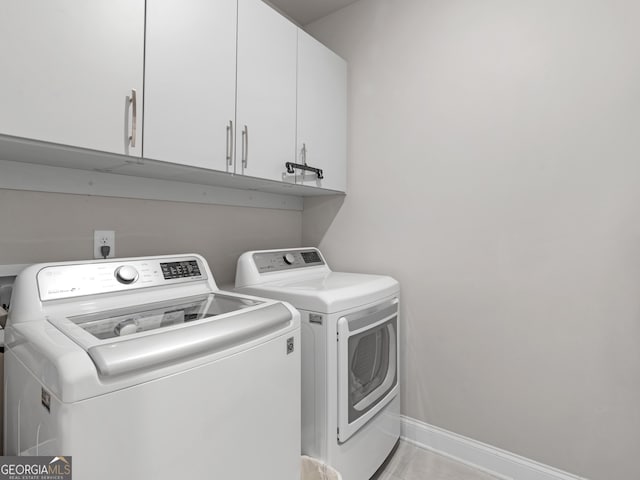 washroom with cabinet space, independent washer and dryer, and baseboards