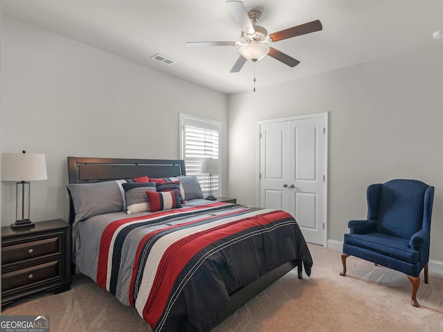 carpeted bedroom featuring baseboards, a closet, visible vents, and a ceiling fan