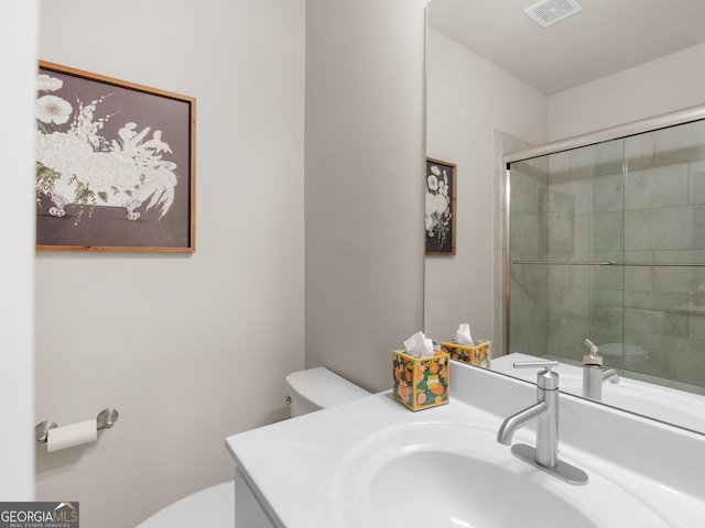 full bathroom featuring visible vents, a tile shower, vanity, and toilet