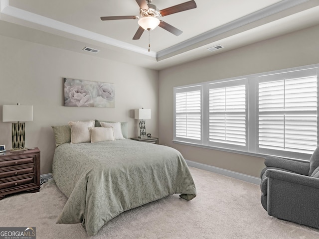 carpeted bedroom featuring baseboards, visible vents, a tray ceiling, and ornamental molding