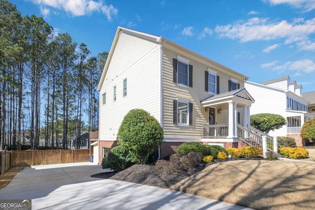 view of front facade featuring metal roof, driveway, a standing seam roof, and fence