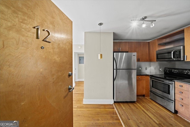 kitchen with baseboards, open shelves, light wood-style flooring, appliances with stainless steel finishes, and dark countertops