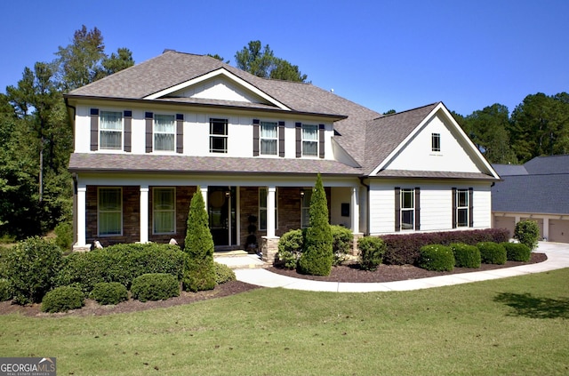 view of front of house with a shingled roof, a porch, and a front lawn