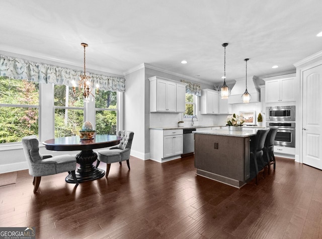 kitchen featuring dark wood-style floors, a kitchen island, stainless steel appliances, and crown molding