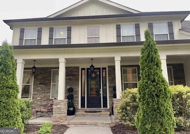 craftsman-style home with board and batten siding, stone siding, and covered porch