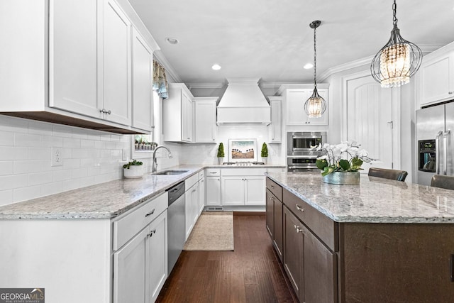 kitchen featuring premium range hood, white cabinetry, stainless steel appliances, and a sink