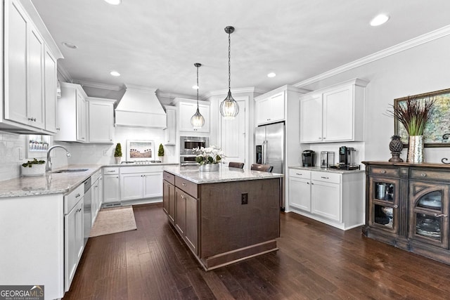 kitchen with white cabinets, custom exhaust hood, stainless steel appliances, and a sink