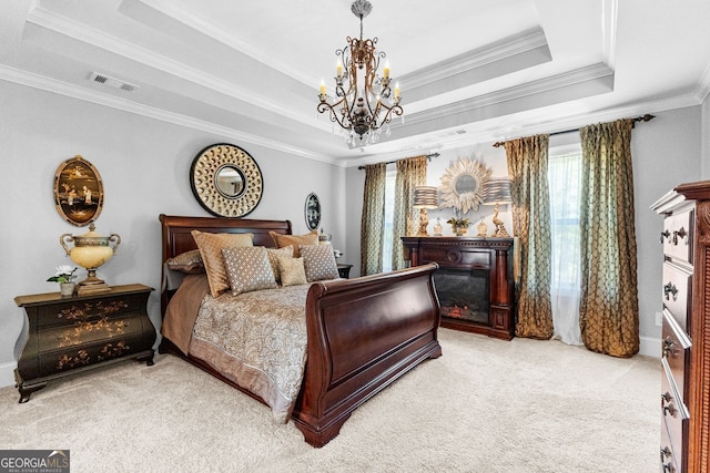 carpeted bedroom with a chandelier, visible vents, a raised ceiling, and a glass covered fireplace