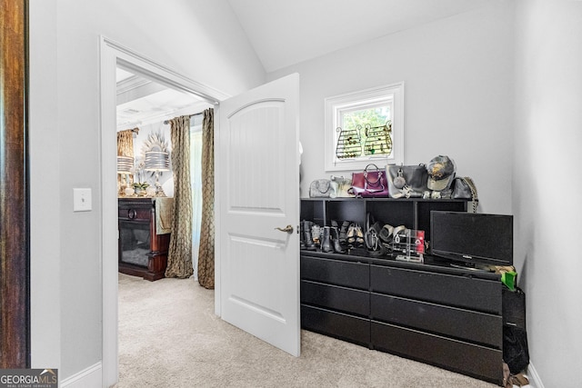 carpeted bedroom featuring lofted ceiling and baseboards