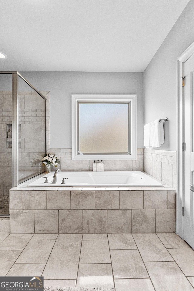 full bathroom featuring a garden tub and a shower stall