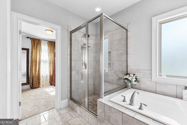 bathroom with a garden tub, a shower stall, and tile patterned floors