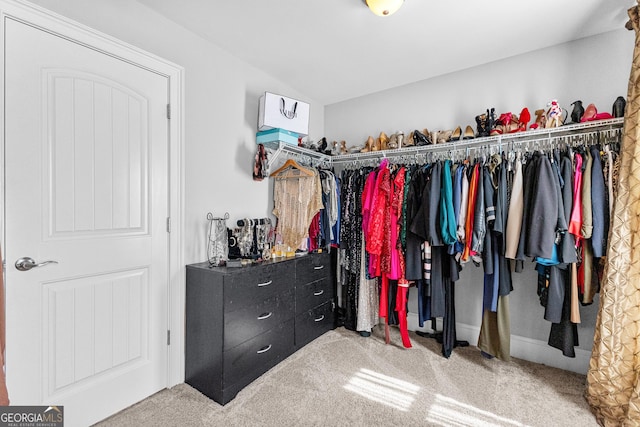 walk in closet with lofted ceiling and carpet flooring