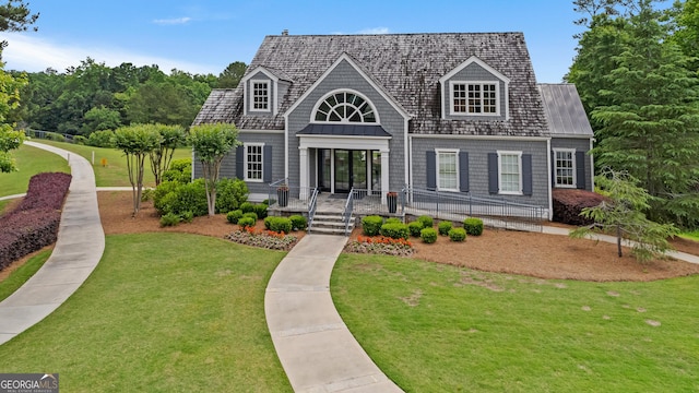 view of front facade with a front yard and metal roof