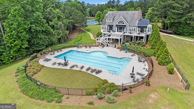 pool featuring stairway, fence, a lawn, and a patio