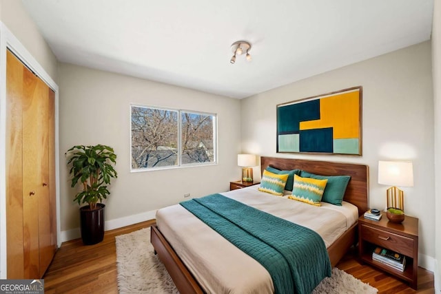 bedroom with a closet, baseboards, and wood finished floors