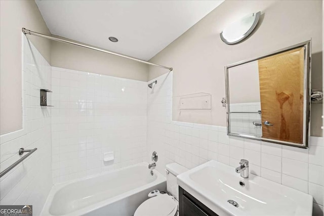 bathroom with toilet, shower / tub combination, tile walls, and vanity