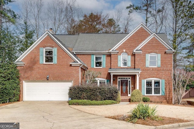 view of front facade featuring a garage, brick siding, driveway, and a chimney