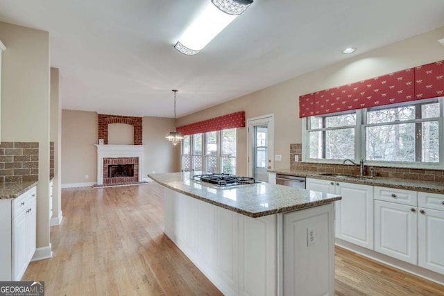 kitchen with stainless steel appliances, backsplash, a sink, and white cabinetry
